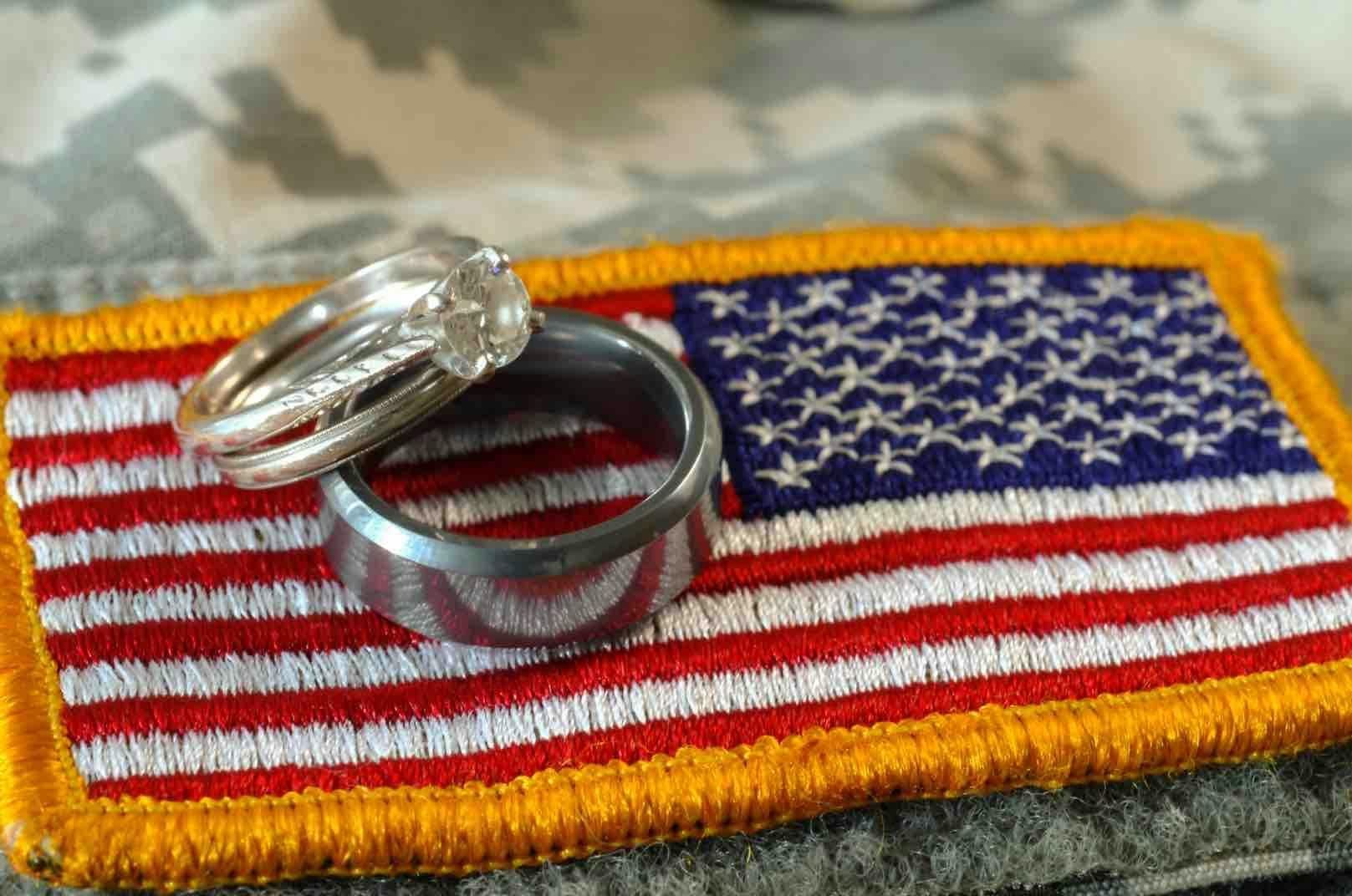 two wedding rights resting on an american flad patch.